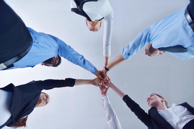 grupo de personas de negocios uniéndose y representando el concepto de amistad y trabajo en equipo, vista de ángulo bajo