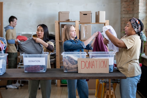 Un grupo de personas de pie alrededor de una mesa con donación en cajas.