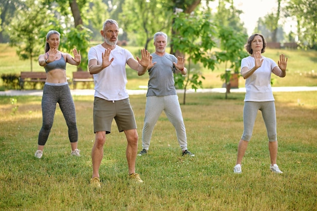 Un grupo de personas practicando qigong en un parque de entrenamiento deportivo en la naturaleza