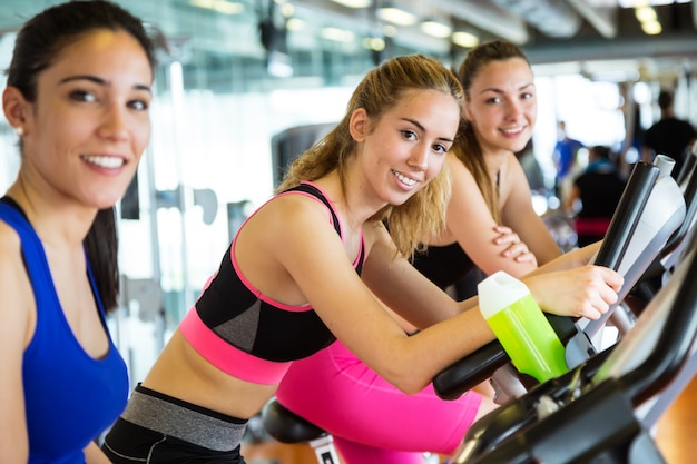 Grupo de personas que ejercen sus piernas haciendo cardio en el gimnasio.