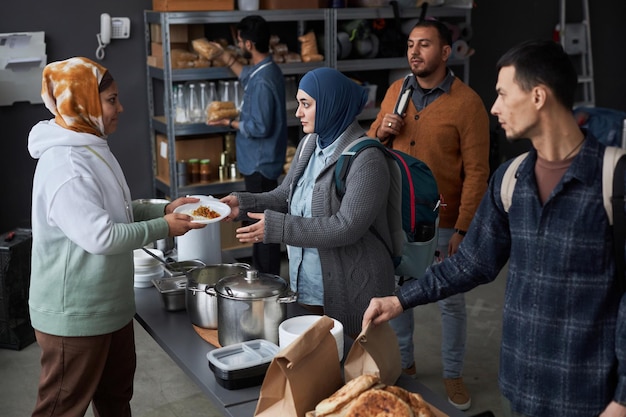 Foto grupo de personas que reciben comidas en el comedor de beneficencia