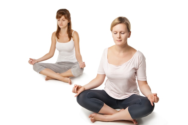 Grupo de personas relajándose y haciendo yoga en blanco