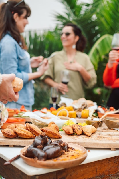 Foto un grupo de personas está reunida alrededor de una mesa con comida y bebidas.