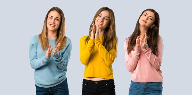 Grupo de personas con ropa colorida aplaudiendo después de la presentación en una conferencia