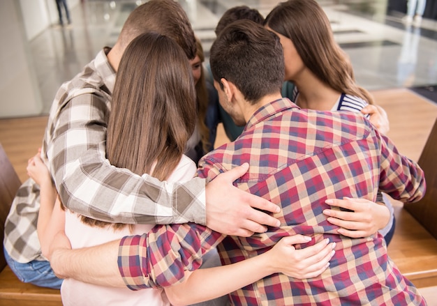 Foto grupo de personas sentadas en círculo y apoyándose mutuamente.