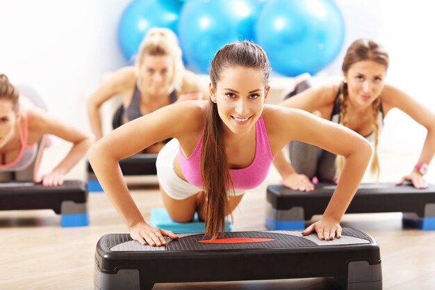 Grupo de personas sonrientes haciendo flexiones