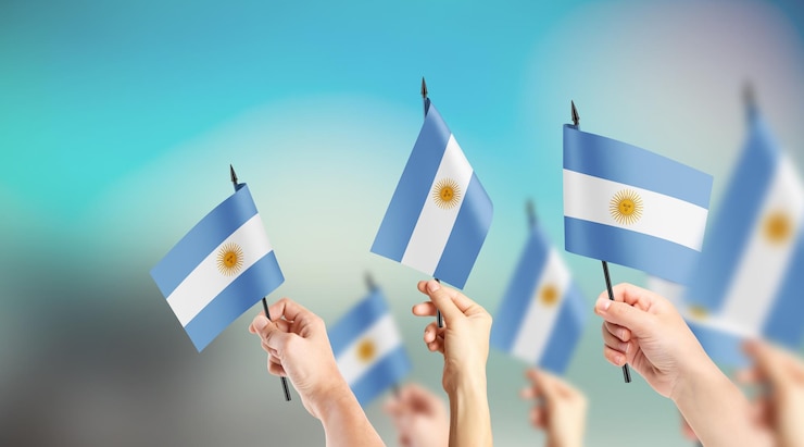 Foto un grupo de personas sostiene pequeñas banderas de argentina en sus manos