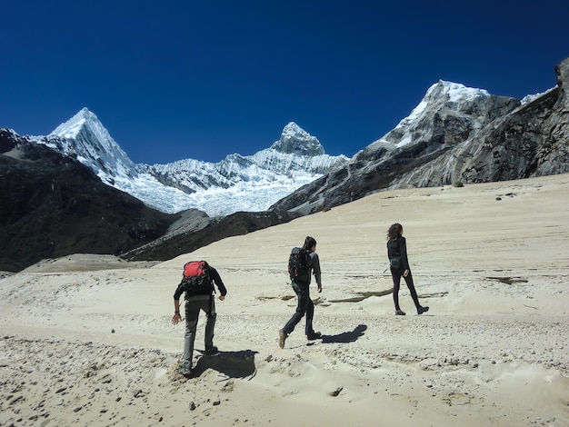 Grupo de personas en su camino a las montañas nevadas de los Andes peruanos