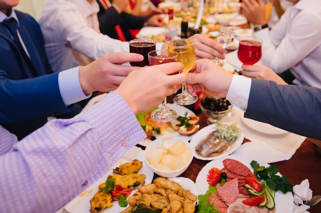 Grupo de personas tintinean copas de vino en el restaurante