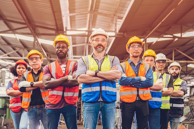 Foto grupo de personas de trabajo en equipo de ingenieros trabajadores mezclan raza en la industria pesada de pie con confianza en el enfoque selectivo en el centro del hombre