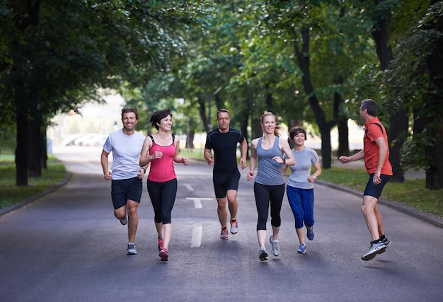 Foto grupo de personas trotando, equipo de corredores en el entrenamiento matutino