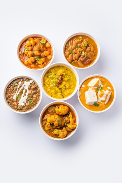 Grupo de platos vegetarianos indios, surtido de comidas calientes y picantes de la cocina Punjabi en tazones