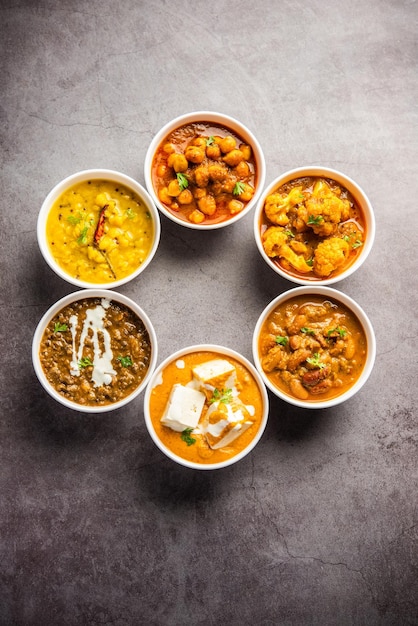 Grupo de platos vegetarianos indios, surtido de comidas calientes y picantes de la cocina Punjabi en tazones