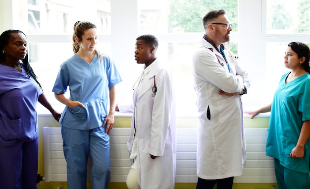 Foto grupo de profesionales médicos discutiendo en el pasillo de un hospital.