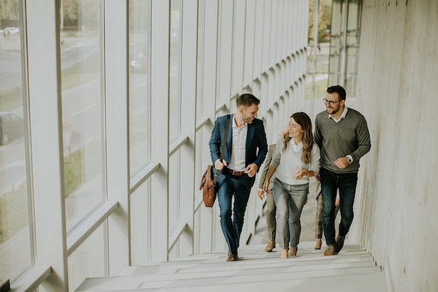 Grupo de profesionales de negocios corporativos subiendo escaleras en el pasillo de la oficina