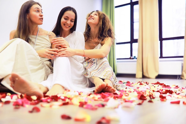 Grupo de Recuperación de Mujeres. Diversas niñas sonrientes tomados de la mano sentados en círculo interior. Enfoque selectivo. Las mujeres se abrazan en un círculo de mujeres.