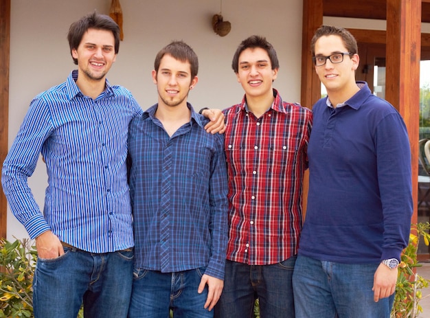 Foto grupo de retratos y hombres jóvenes hermanos al aire libre y felicidad con lazos de amor y hermanos enfréntate a hombres felices y chicos afuera sonríen y abrazan con ropa informal de libertad y apoyo