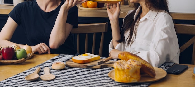 Grupo de risa de mujer joven diversa pasando el rato en casa juntos y comiendo pizza