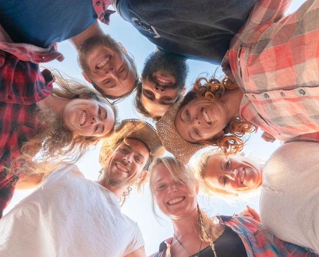 Grupo de siete personas mirando a la cámara en el suelo - gente en círculo sonriendo y divirtiéndose juntos - concepto de vista del suelo