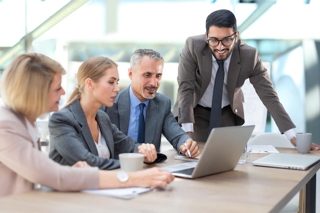 Grupo de socios comerciales discutiendo ideas y planificando trabajos en la oficina