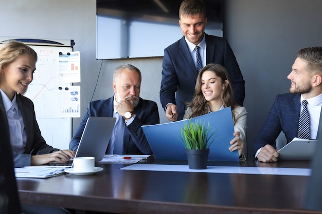 Grupo de socios comerciales que discuten ideas y planifican el trabajo en la oficina.