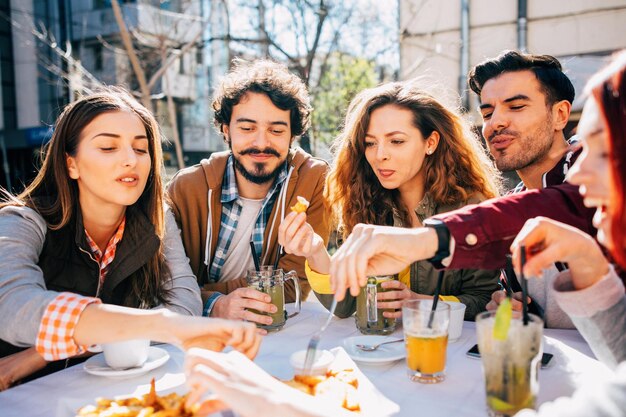 Grupo sonriente de diversos empresarios que trabajan juntos alrededor de una mesa de reuniones en el vestíbulo de un complejo de oficinas