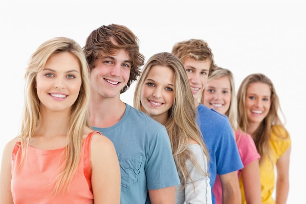 Un grupo sonriente de pie detrás de la otra