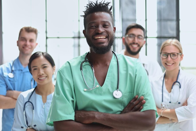 Grupo sorridente de cientistas em laboratório moderno com raça de mistura de líder afro-americano masculino