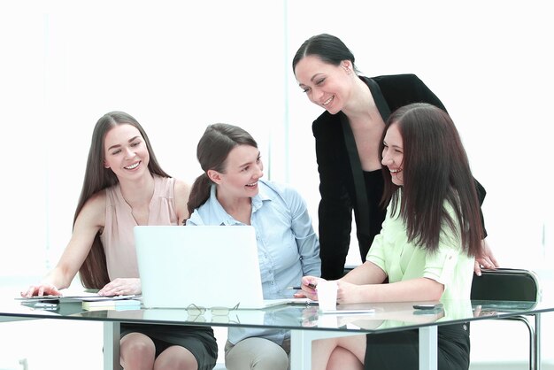 Grupo sorridente de mulheres atrás de uma mesa no escritório