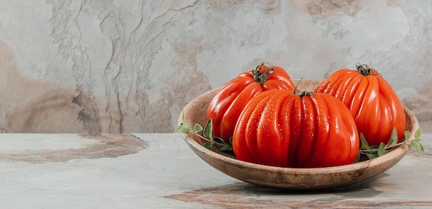 Un grupo de tomates grandes Costoluto con orégano en un espacio de fondo marrón para texto