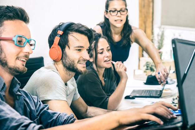 Grupo de trabajadores empleados jóvenes con computadora en estudio de inicio