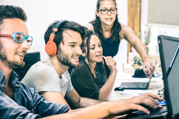 Foto grupo de trabajadores empleados jóvenes con computadora en estudio de inicio