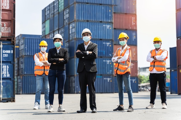 Grupo de trabajadores del personal de pie y revisando la caja de contenedores del buque de carga para exportación e importación