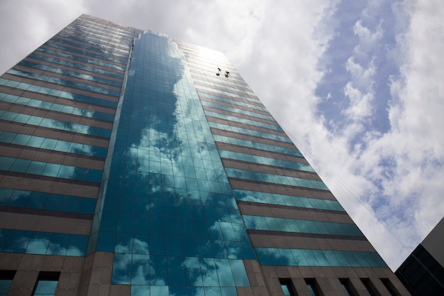 Grupo de trabajadores que limpian el servicio de ventanas en el edificio alto