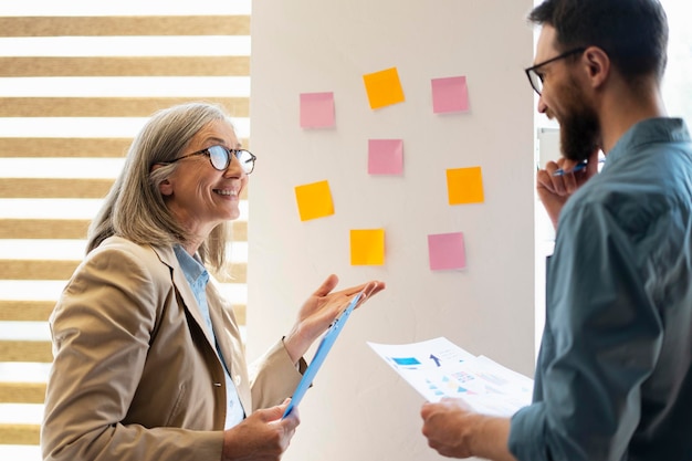 Grupo de trabajo en equipo de negocios exitoso y diverso Reunión de lluvia de ideas con coloridas notas adhesivas en la pared para nuevas ideas Uso de metodología ágil y hacer negocios Lluvia de ideas en la oficina de inicio de tecnología