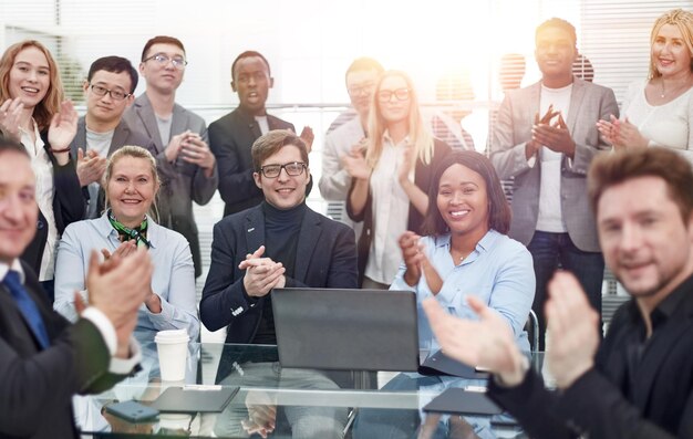 Grupo de trabajo multinacional celebrando juntos cerca del escritorio