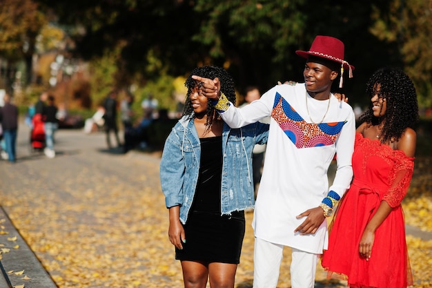 Grupo de tres elegantes amigos de moda afro francia posaron en el día de otoño Modelo de hombre africano negro con dos mujeres de piel oscura