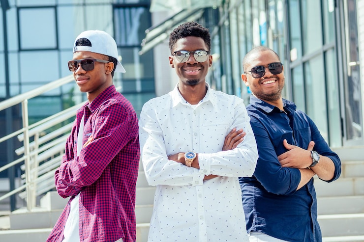 Foto un grupo de tres estudiantes afroamericanos frescos y bien vestidos de moda que se comunican en la calle.