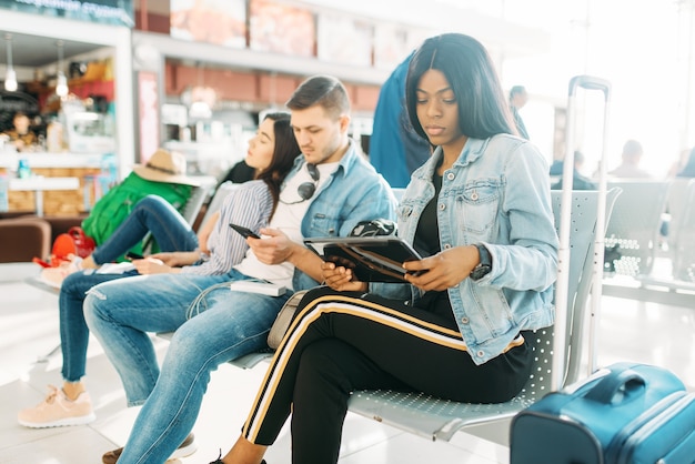 Grupo de turistas esperando la salida en el aeropuerto