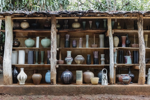 Foto grupo de utensilios de cocina de cerámica artesanal dispuestos en estantes