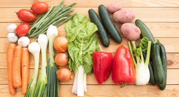 Grupo de vegetales orgánicos crudos clasificados en una mesa de madera. Dieta de desintoxicación vegana y vegetariana