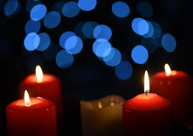 Un grupo de velas rojas con luces azules detrás de ellas.