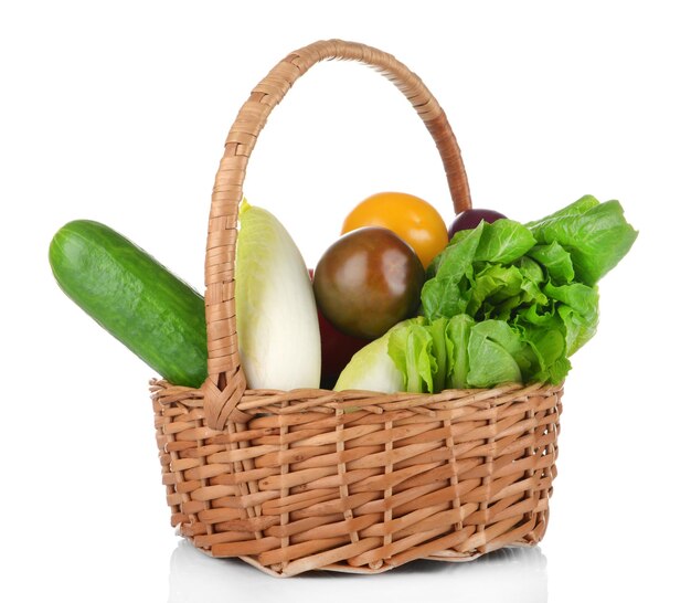 Grupo de verduras frescas en cesta sobre fondo blanco.