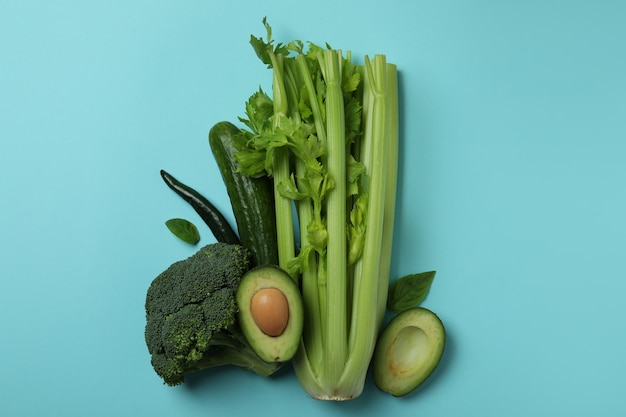 Grupo de verduras frescas sobre fondo azul.