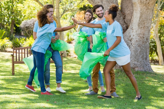 Grupo de voluntarios que se divierten mientras recogen basura