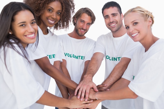 Grupo de voluntarios sonriente juntando las manos