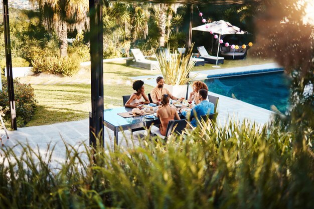 Grupos de amigos o comiendo en un restaurante al aire libre para relajarse en celebraciones de vacaciones o vacaciones en verano juntos Hotel de fiestas o personas felices hablando para vincularse en la mesa para el almuerzo o el brunch