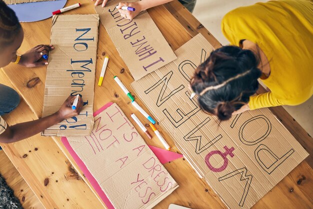 Foto grupos de chicas firman y escriben para la vista superior de protesta y apoyo al poder y los objetivos de la diversidad en el hogar afiche de cartón de amigas y diseño con vallas publicitarias para la justicia, los derechos humanos o la inclusión