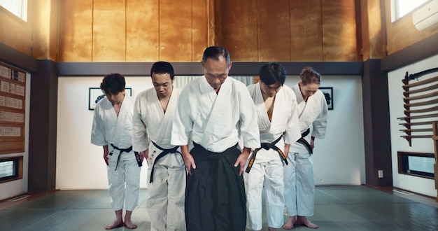 Grupos de artes marciais homens e arco para exercício respeito ou honra para lutar conflito ou competição em dojo estudantes de cinturão preto sensei japonês sênior e aikido com treinamento treino ou disciplina