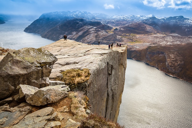 Grupos de turistas em pé na borda da rocha do púlpito (preikestolen)